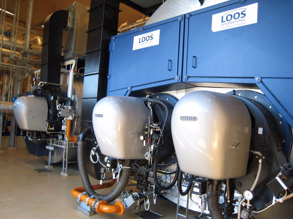 Two large blue industrial boilers from LOOS International, complete with burners, piping, and technical equipment.